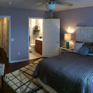 A cozy bedroom with a large bed, nightstand, and an open doorway leading to a bathroom.