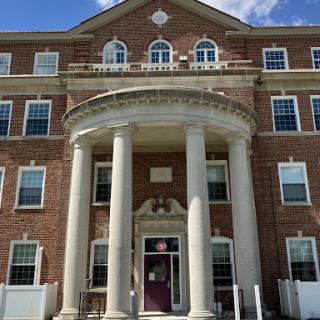 A historic brick building featuring elegant columns and detailed architecture.