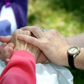 Two people holding hands, symbolizing support and companionship.