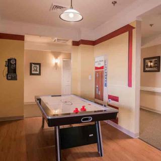 A recreational room featuring an air hockey table and cozy lighting.