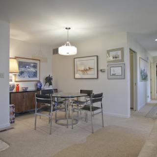 A stylish and modern dining area featuring a sleek table, comfortable chairs, and tasteful artwork.