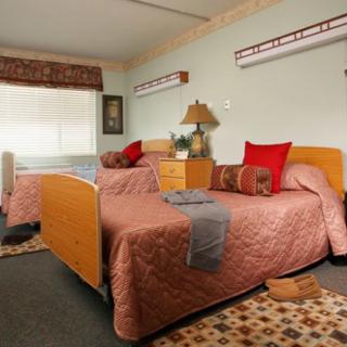 A cozy bedroom with twin beds, decorated in warm tones.