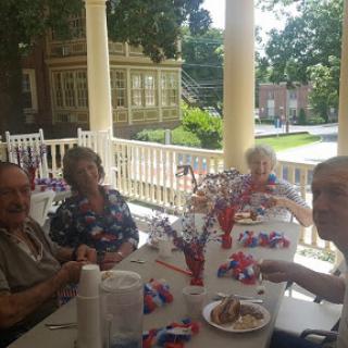 A joyful afternoon gathering on the porch with friends, celebrating togetherness in a festive atmosphere.