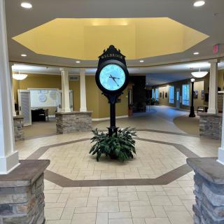 A spacious lobby with a central clock and elegant lighting.