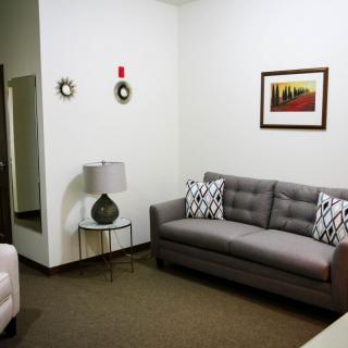 A cozy living room with a gray sofa and modern decor.