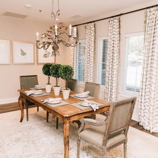 An elegant dining room with a wooden table, stylish chairs, and a decorative chandelier.