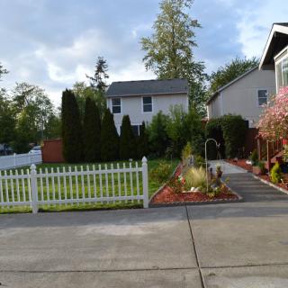 A suburban home with a neatly maintained garden and white picket fence.
