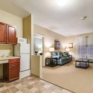A cozy apartment interior featuring an open living room and kitchen area with comfortable furnishings.