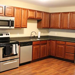 A modern kitchen featuring wooden cabinets and stainless steel appliances.