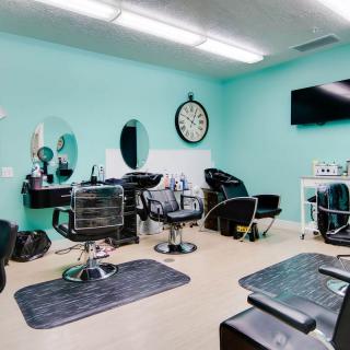 A modern hair salon interior with chairs and mirrors.