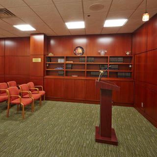A professional conference room with wood paneling, a podium, and seating.