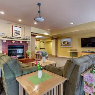 A cozy living room with a fireplace, comfortable seating, and elegant decor.