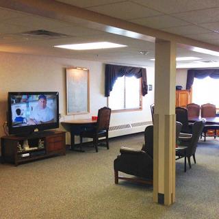 A cozy living room with a television, comfortable seating, and a window providing natural light.