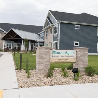 A modern building with a sign labeled 'Home Again' in the foreground.