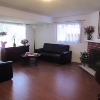 A cozy living room with dark sofas, a coffee table, and a fireplace.