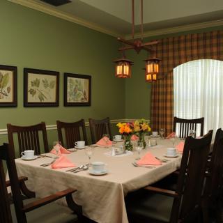 A beautifully set dining room table with floral decor and warm lighting.