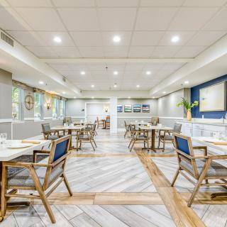 A modern and spacious restaurant interior with neatly arranged tables and chairs.