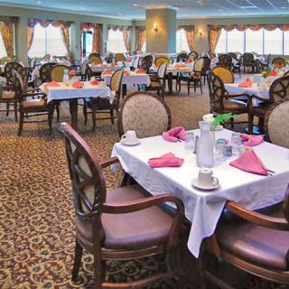 An elegant dining room with tables set for a formal meal.
