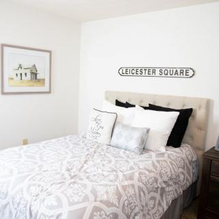 A minimalist bedroom with a neatly made bed and wall art.