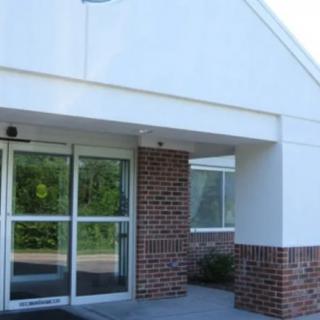 Front entrance of a building with brick and glass elements.