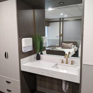 A sleek and modern bathroom with a stylish sink, mirror, and decorative elements.