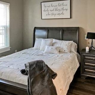 A cozy bedroom with a neatly made bed and modern furnishings.
