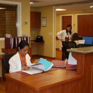 Employees working at a reception desk in an office setting.