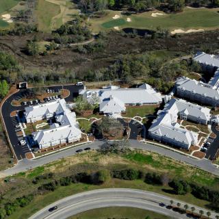 Aerial view of a residential complex with multiple buildings surrounded by roads and greenery.