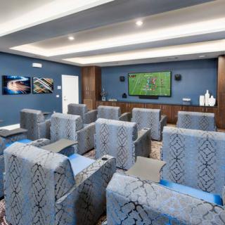 A modern conference room with comfortable seating and a large television for presentations.
