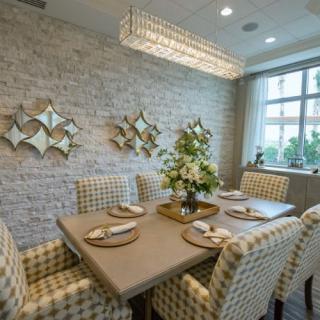 A modern dining room with a stylish chandelier, decorative wall art, and an elegant table setting.