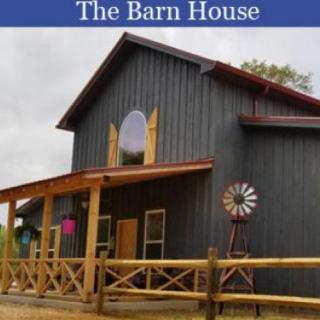 A rustic barn-style house with a porch and wooden architecture.