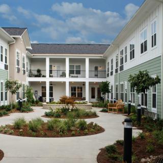 A courtyard view of a modern residential building with well-maintained landscaping.