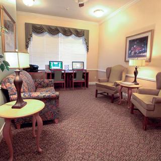 A cozy living room with comfortable seating and computer desks in a well-lit area.