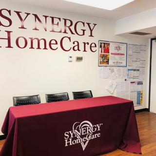 A welcoming reception area of Synergy HomeCare featuring a branded table and seating.