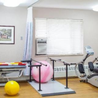 A well-equipped physical therapy room with exercise balls and machines.