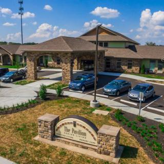 A building with a parking lot and several cars parked under a clear blue sky.