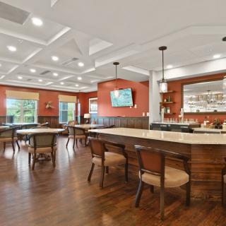 Modern restaurant interior with a bar and dining tables.