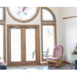 A cozy living space with large windows and a rocking chair.