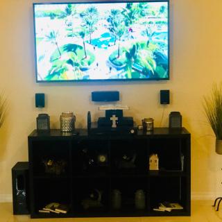 A modern living room setup with a mounted TV, entertainment center, and decorative elements.