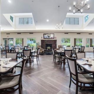 A spacious and elegantly designed dining area with modern furnishings and a central fireplace.