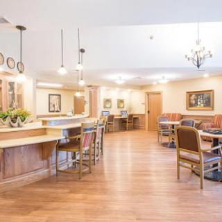 A spacious and inviting lounge area featuring warm wooden floors and comfortable seating arrangements.