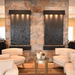 A modern lounge area with comfortable seating and decorative water features.