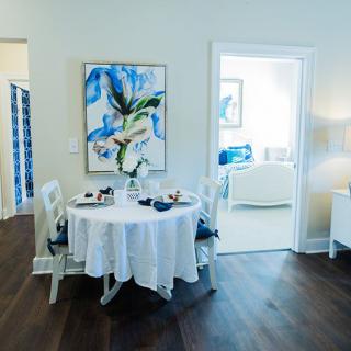 A cozy dining area with a round table, surrounded by chairs and adorned with artistic decor.