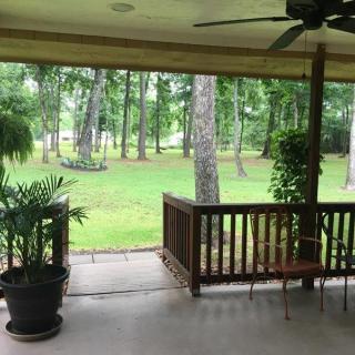 A serene patio area overlooking a lush garden with trees and plants.