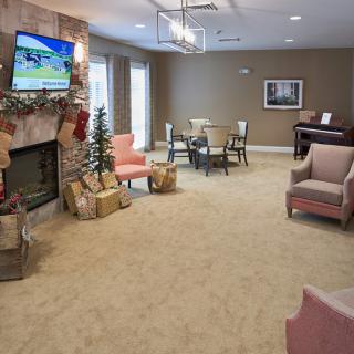A cozy living room with comfortable armchairs, a fireplace, and a television.