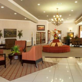 A stylish hotel lobby featuring elegant furniture and a grand chandelier.