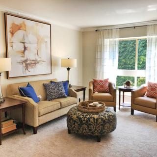A cozy living room with stylish furniture and a large window letting in natural light.