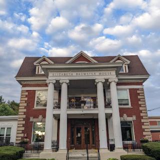 A beautifully designed historical building featuring elegant pillars and a classic architectural style under a cloudy sky.
