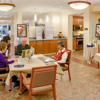 A cozy interior space where a group of seniors are gathered around a table in a communal area.