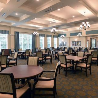 A spacious dining room with elegant furniture and multiple windows.